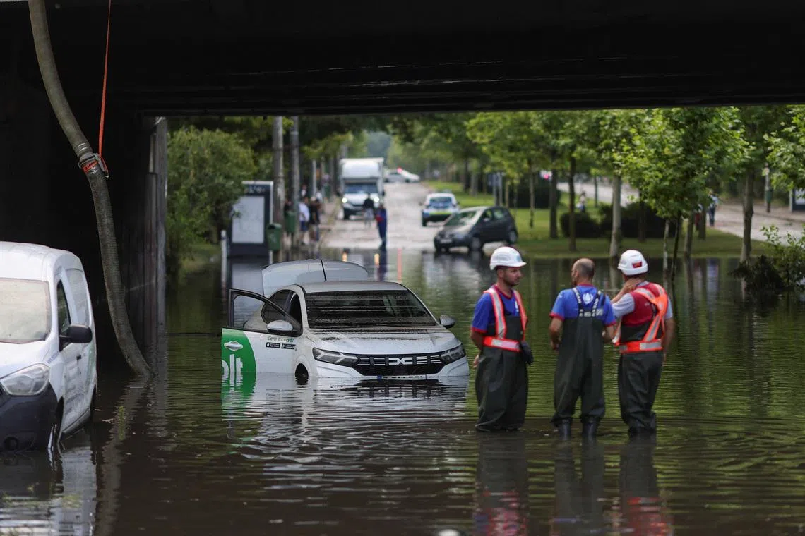 Workers watch as rainwater is pumped out of a flooded railway underpass in northern Bucharest, Romania, July 1, 2026. Inquam Photos/Octav Ganea via REUTERS