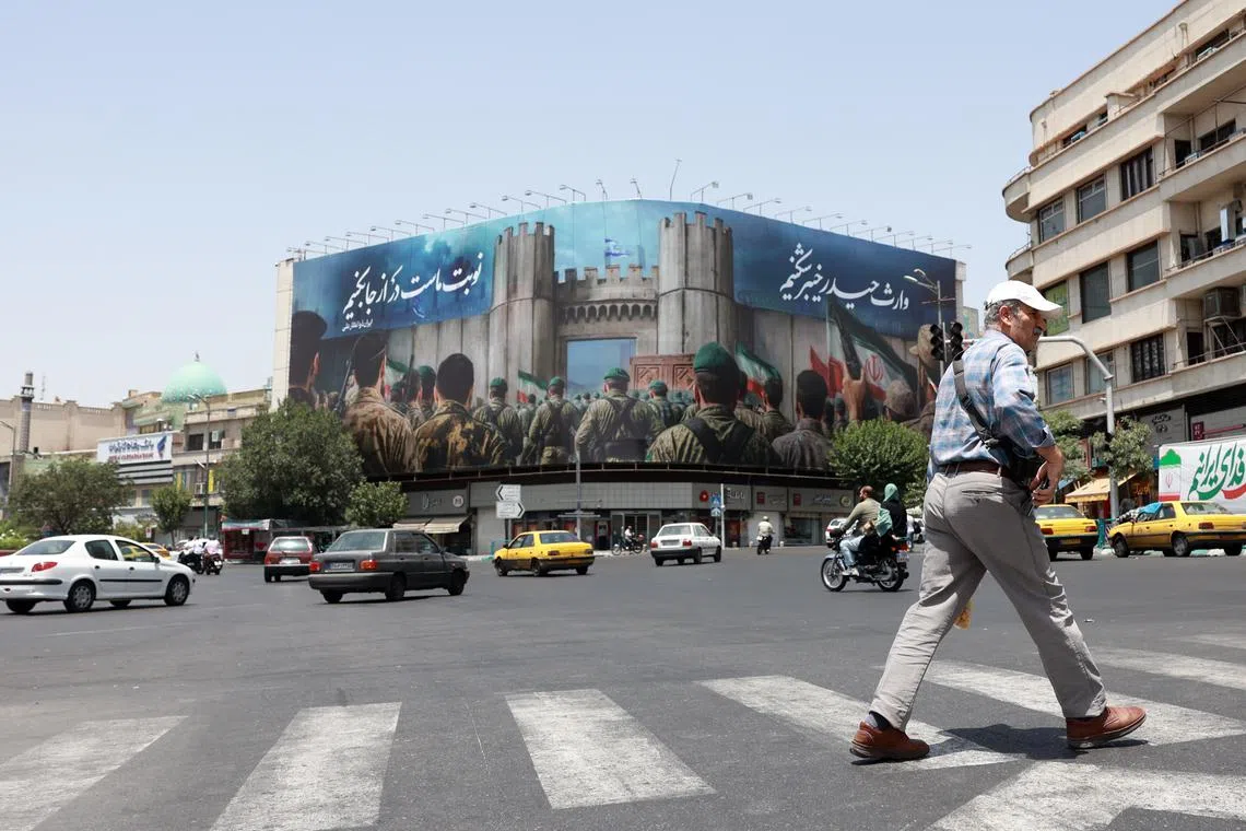 epa12194168 An Iranian man crosses a street near an anti-Israeli billboard reading in Persian 'Now is our turn' in Tehran, Iran, 24 June 2025. Israel's military on 24 June, accused Iran of violating a ceasefire by launching missiles into Israeli airspace. Iran's General Staff of the Armed Forces Abdolrahim Mousavi denied firing any missiles towards Israel, Iranian state media reported. EPA/ABEDIN TAHERKENAREH