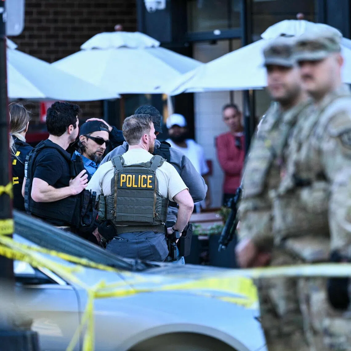 Law-enforcement officers secure the area after a shooting in downtown Washington, on November 26, 2025. On November 26, Police in Washington said they had detained a suspect after two National Guard troops were shot blocks away from the White House. "The scene is secured. One suspect is in custody," The DC Police posted on X. (Photo by Brendan SMIALOWSKI / AFP)
