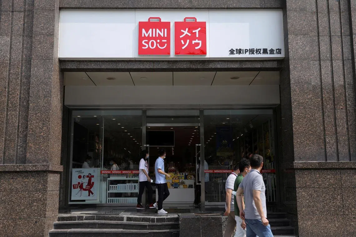 People walk past a store of Chinese retailer MINISO Group in Beijing, China September 13, 2021. Picture taken September 13, 2021. REUTERS/Tingshu Wang/File Photo