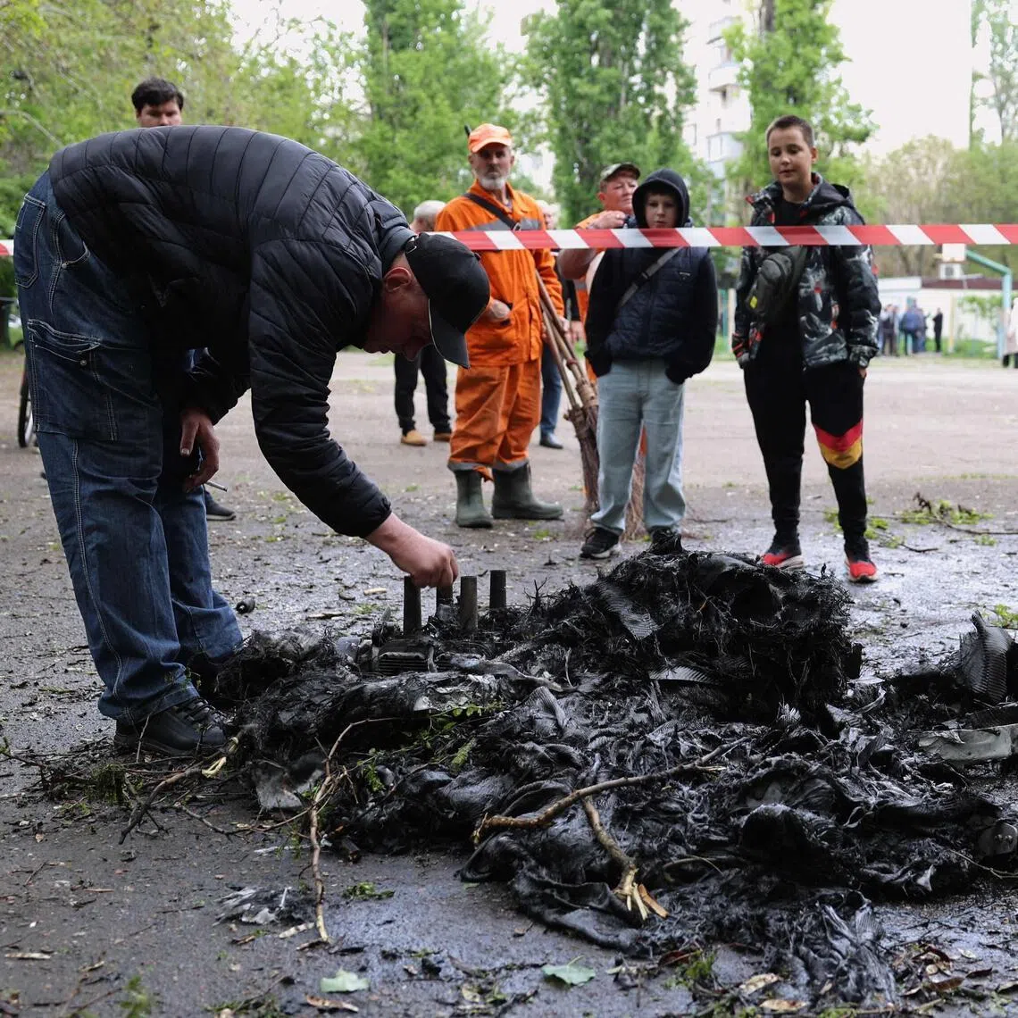 A man inspecting the remnants of a drone in the courtyard of a residential building in Odesa on May 13, following a Russian attack.