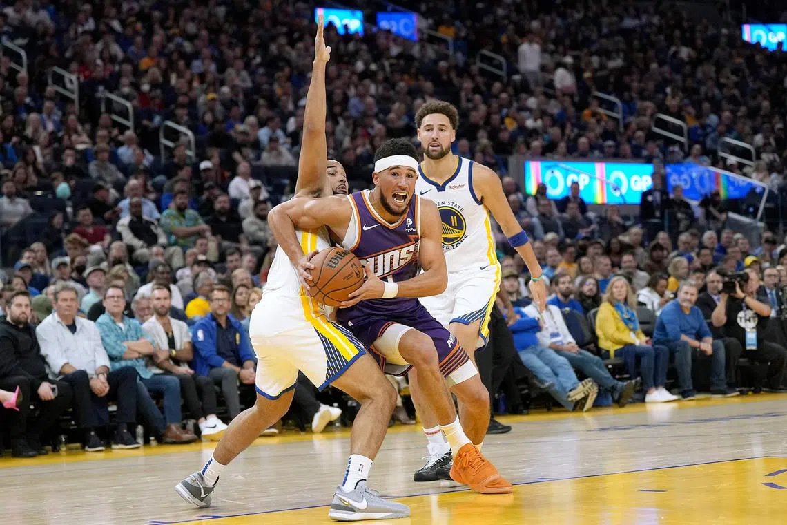 SAN FRANCISCO, CALIFORNIA - OCTOBER 24: Devin Booker #1 of the Phoenix Suns drives to the basket on Cory Joseph #1 of the Golden State Warriors during the second quarter at Chase Center on October 24, 2023 in San Francisco, California. NOTE TO USER: User expressly acknowledges and agrees that, by downloading and or using this photograph, User is consenting to the terms and conditions of the Getty Images License Agreement.   Thearon W. Henderson/Getty Images/AFP (Photo by Thearon W. Henderson / GETTY IMAGES NORTH AMERICA / Getty Images via AFP)