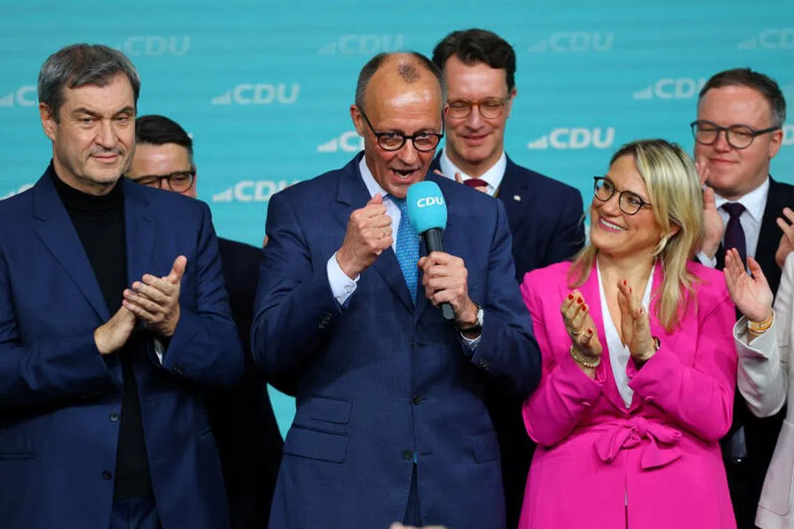 German conservative candidate for chancellor and Christian Democratic Union (CDU) party leader Friedrich Merz, flanked by Bavarian state premier and leader of the Christian Social Union (CSU) Markus Soeder, speaks after the exit poll results are announced for the 2025 general election, in Berlin, Germany, February 23, 2025. REUTERS/Fabrizio Bensch