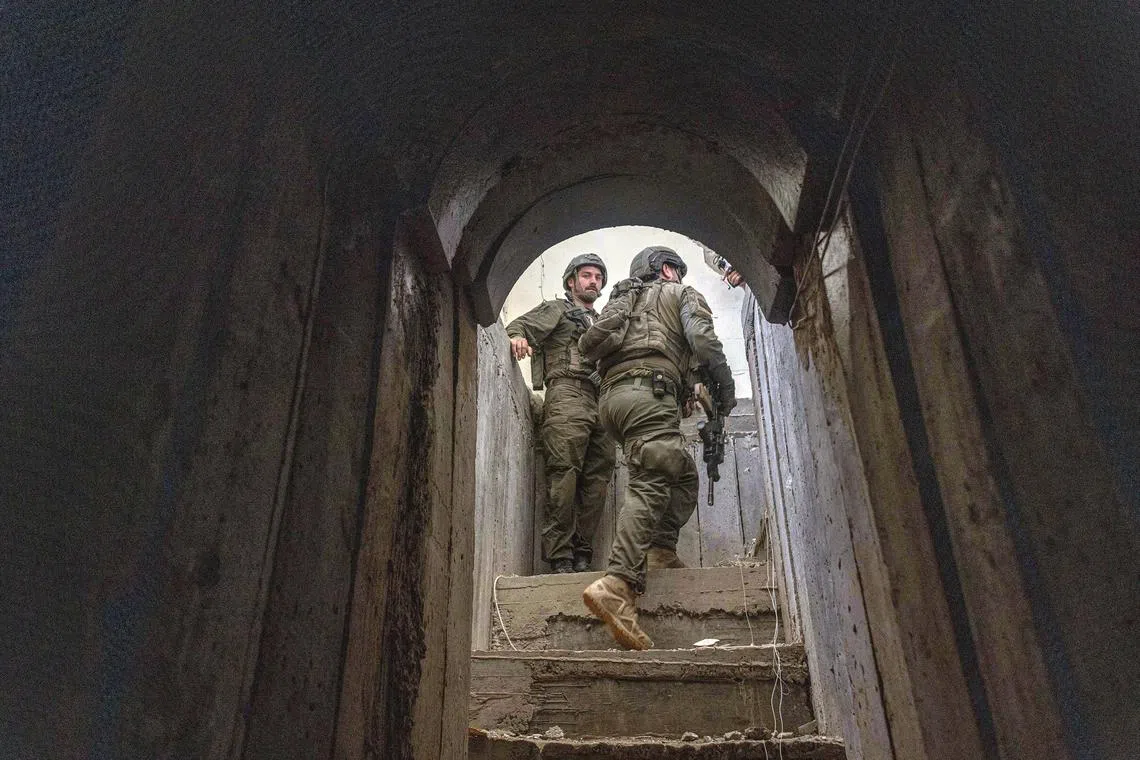 Israeli soldiers walk out of tunnel found inside the home of a Palestinian family during an escorted tour by the Israeli military for journalists, in the central Gaza Strip, Jan. 8, 2024. The Israel military, surprised by the extent, depth and quality of the tunnel network under the Gaza Strip, now estimates that it is more than 450 miles long. (Avishag Shaar-Yashuv/The New York Times)