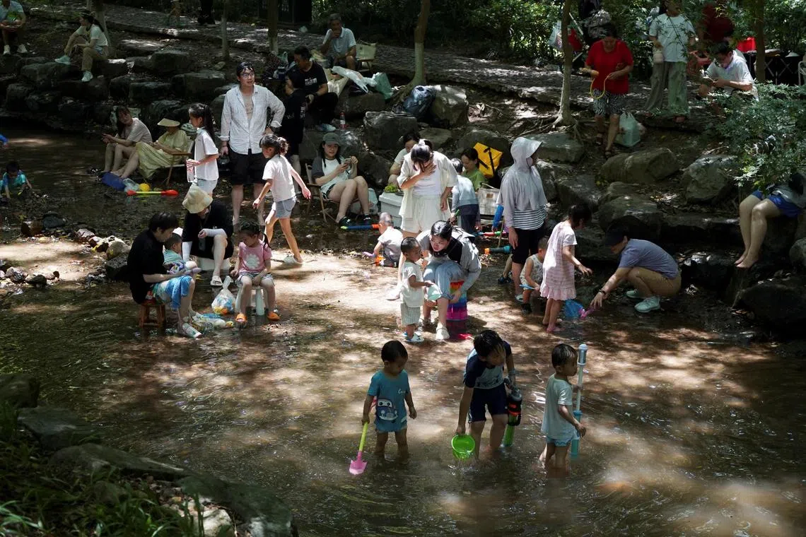 People cool off in a stream amid a heatwave in Hangzhou.