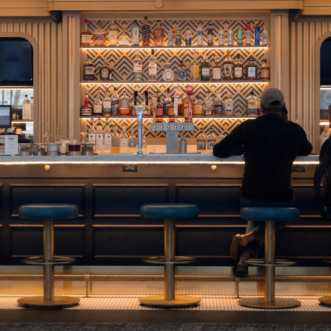 FILE PHOTO: A man sits at a bar in LaGuardia Airport in Queens, New York City, U.S., July 30, 2025. REUTERS/Kylie Cooper/File Photo