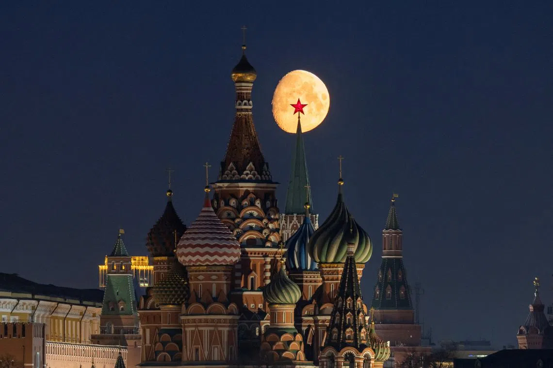 FILE PHOTO: The moon rises behind St. Basil's Cathedral and towers of the Kremlin in central Moscow, Russia, March 21, 2024. REUTERS/Marina Lystseva