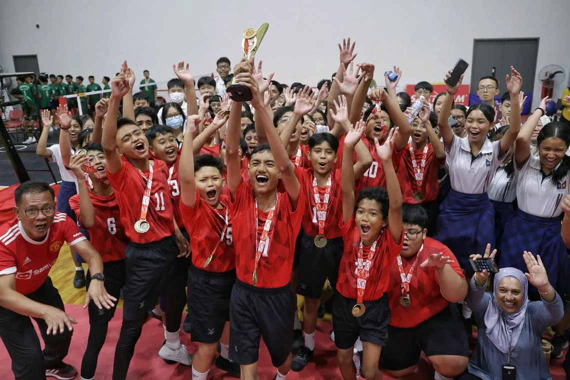 Marsiling Secondary School's Nick Daniel Maliqi Abdullah holding the trophy aloft as his team and supporters celebrating their win in the National School Games C Division boys sepak takraw final against Northlight School at Heartbeat@Bedok on Aug 12, 2024.