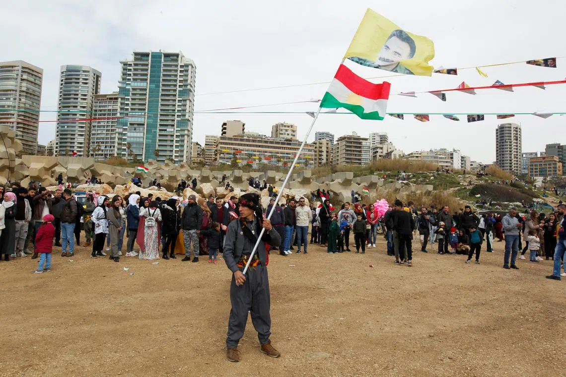 FILE PHOTO: A Kurdish man carries a flag with a portrait of jailed Kurdistan Workers Party (PKK) leader Abdullah Ocalan during Nowruz festival celebrations, in Beirut, Lebanon March 20, 2022. REUTERS/Aziz Taher/File Photo