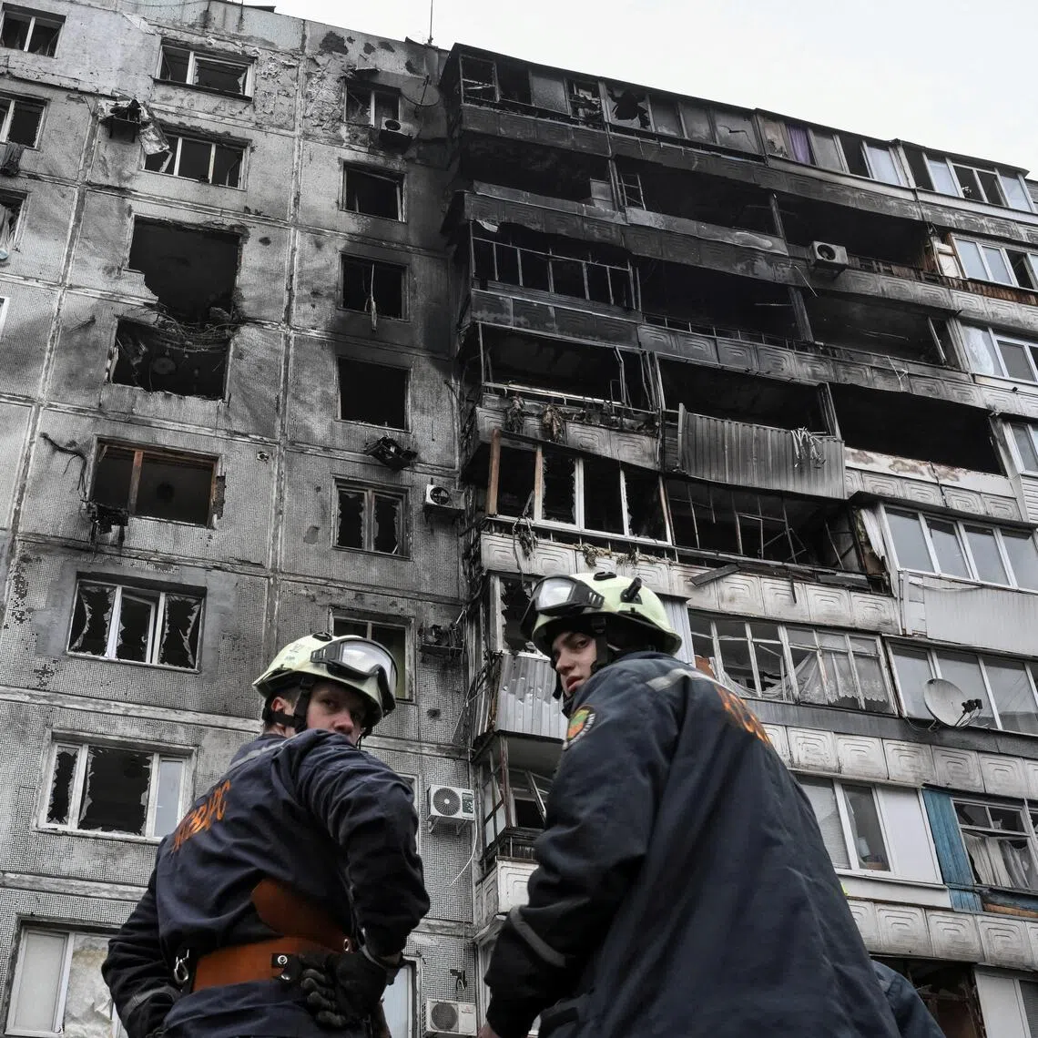 Rescuers standing near an apartment building hit by a Russian drone strike, in the Ukrainian city of Zaporizhzhia, on Dec 16.