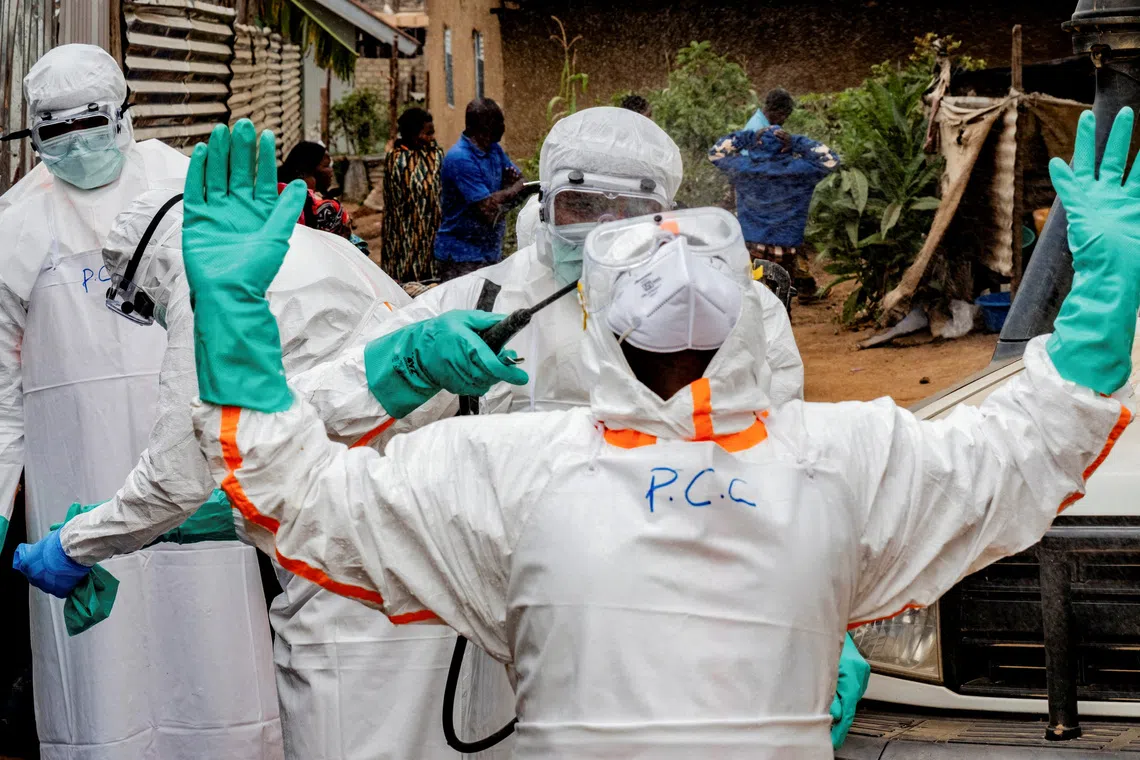 FILE PHOTO: Members of the Civil Protection team, which works to help mitigate the spread of the Ebola virus, wearing personal protective equipment (PPE), disinfect after handling the body of an unidentified man, who according to his family, died of Ebola, in Bunia, Ituri province, Democratic Republic of Congo, July 10, 2026. REUTERS/Gradel Muyisa Mumbere/File Photo