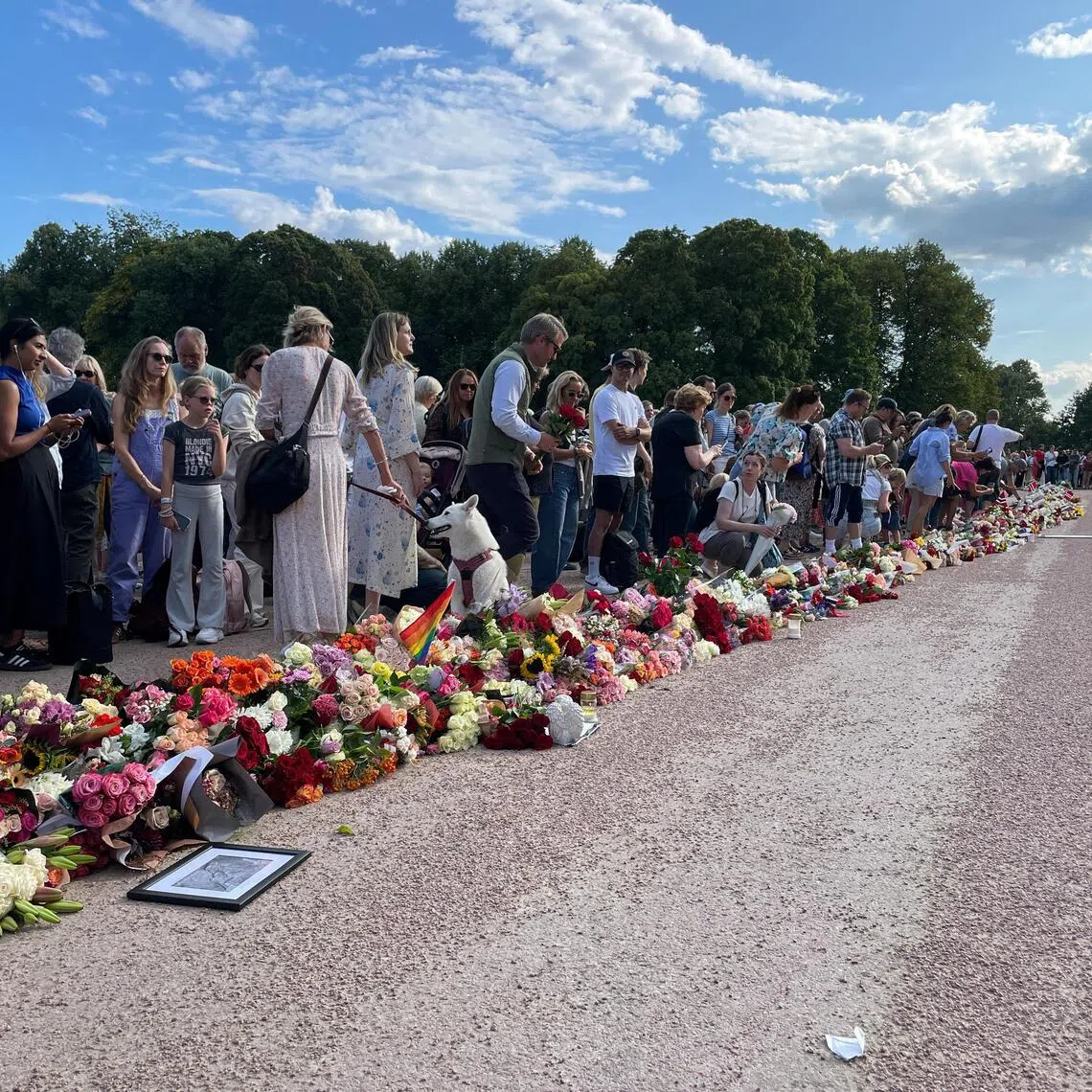 Hundreds of people gathering outside the Royal Palace in Oslo on Aug 27, 2026, with many laying flowers, as Norway’s King Harald is hospitalised.