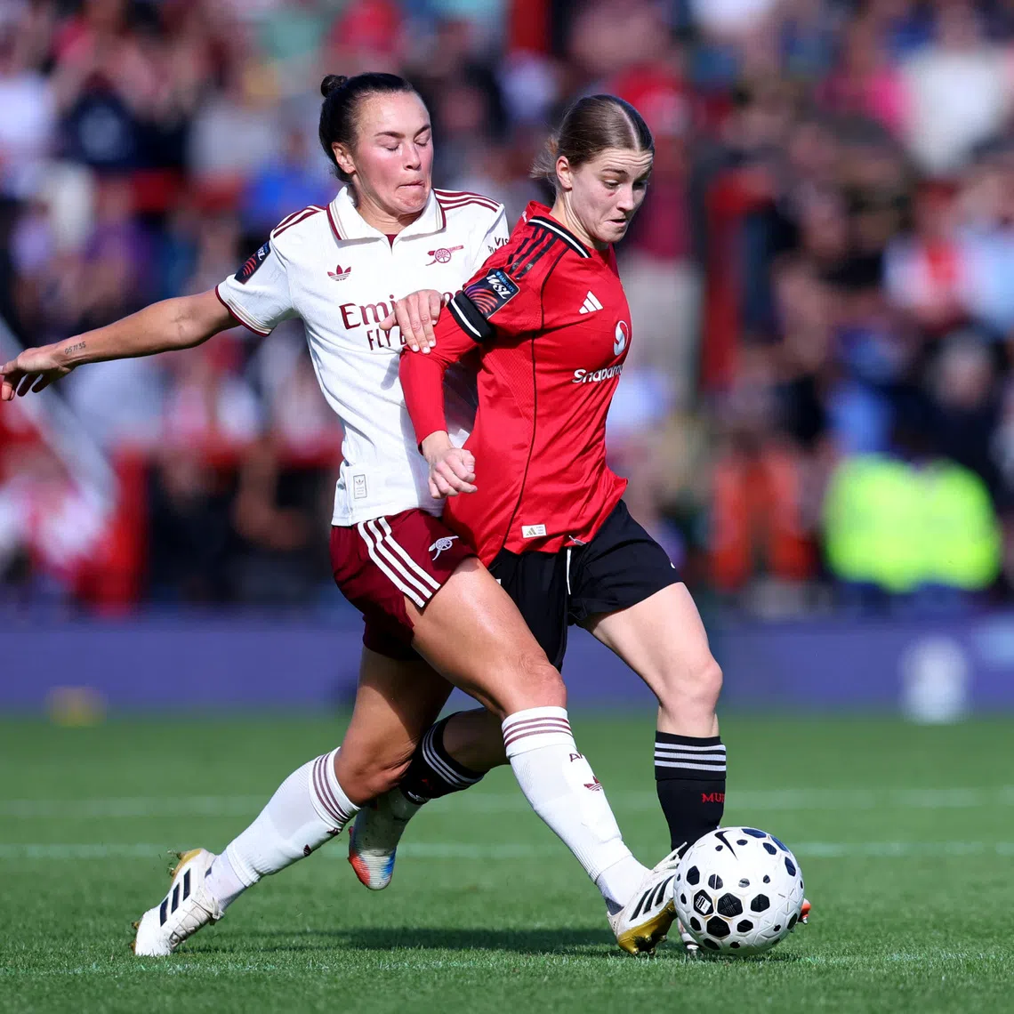 Soccer Football - Women's Super League - Manchester United v Arsenal - Leigh Sports Village, Leigh, Britain - September 21, 2025 Arsenal's Caitlin Foord in action with Manchester United's Jessica Park Action Images via Reuters/Craig Brough