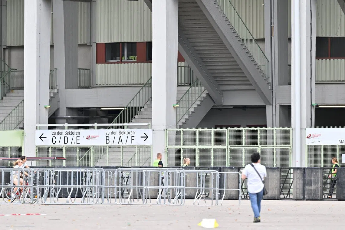 People and security walk outside Happel stadium after Taylor Swift's three concerts this week were canceled after the government confirmed a planned attack at the stadium in Vienna, Austria, August 8, 2024. REUTERS/Elisabeth Mandl