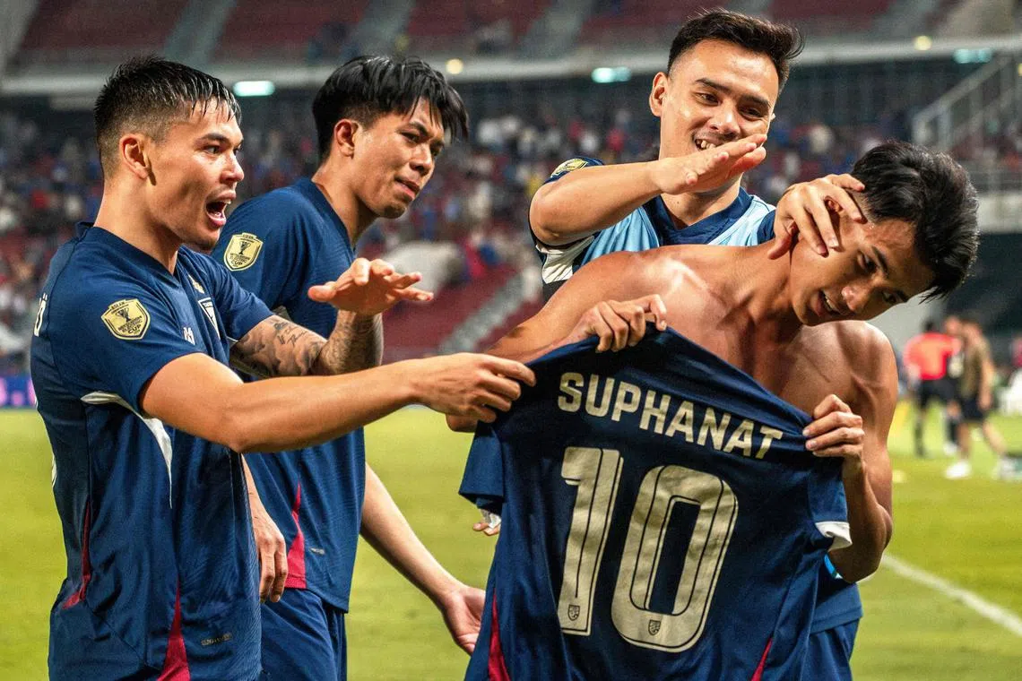 Thailand's forward Suphanat Mueanta (right) celebrating with teammates after scoring against the Philippines in Bangkok on Dec 30.
