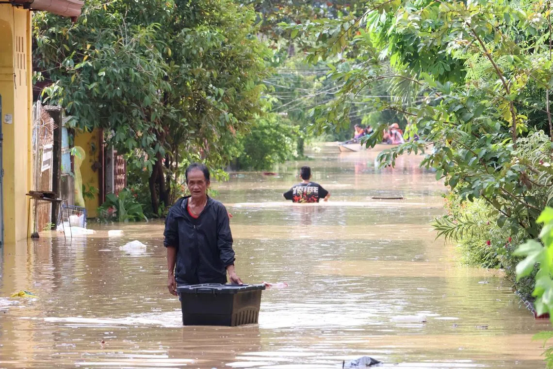 A man wades through a flooded street in northern Philippines days Typhoon Toraji tore across the country.