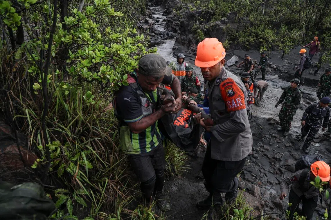 epa12943724 Rescuers carry the body of a victim of Mount Dukono Volcano eruption in North Halmahera, Indonesia, 09 May 2026. According to the Indonesia’s rescue agency (Basarnas), the rescuers have recovered the body of an Indonesian hiker while two Singaporean hikers remain missing.  EPA/NIZAM