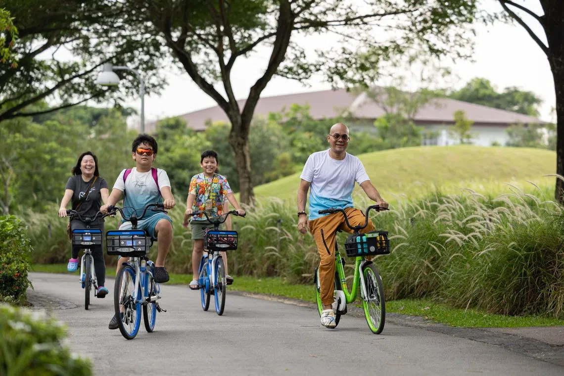 ST20240714_202460991046/elbike27/Brian Teo/Esther Loi/ Mr Daren Oliveiro, 43, Hawker, riding rental bikes with his wife Vivian Liem, 38, and two sons Davian Oliveiro, 11, and Arius Oliveiro, 9, Lakeside Primary School students, at Jurong Lake Garden on July 14, 2024. The convenience of bike-sharing bikes allows Daren to use cycling as a way to bond with his family. ST PHOTO: BRIAN TEO.