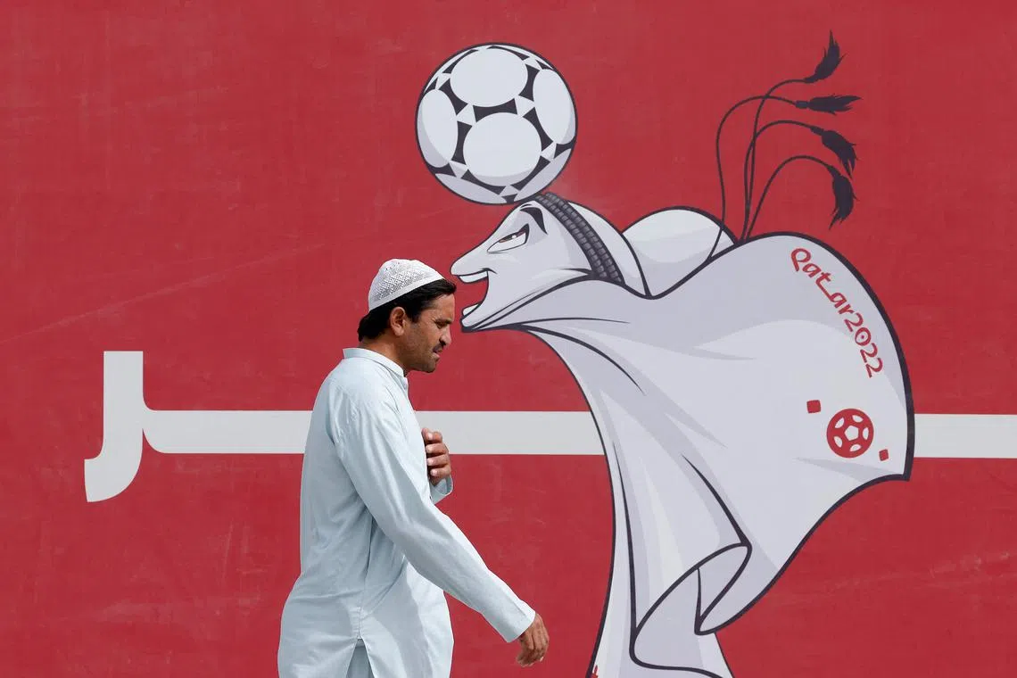  A man walks past a poster of the Qatar 2022 mascot La'eeb in Doha on November 9, 2022, ahead of the Qatar 2022 FIFA World Cup football tournament. 