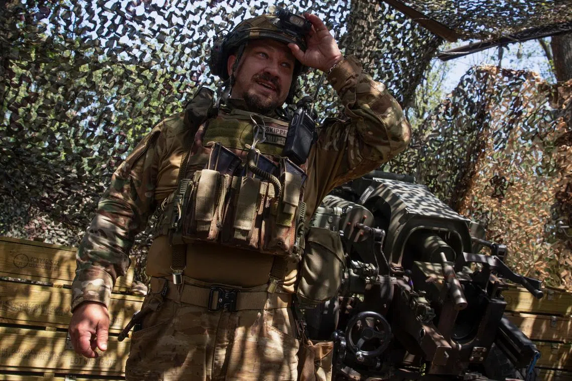 A Ukrainian serviceman stands next to a M119 howitzer in Ukraine's Donetsk region.