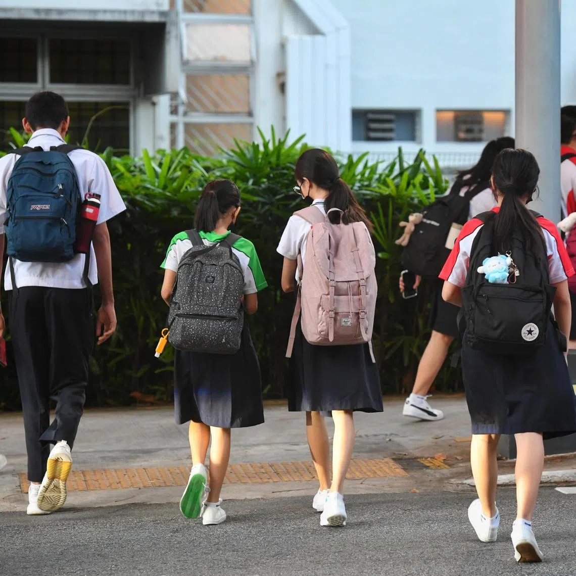 Back view of students from Bukit Merah Secondary School crossing the road at the pedestrian crossing taken on June 27, 2022.