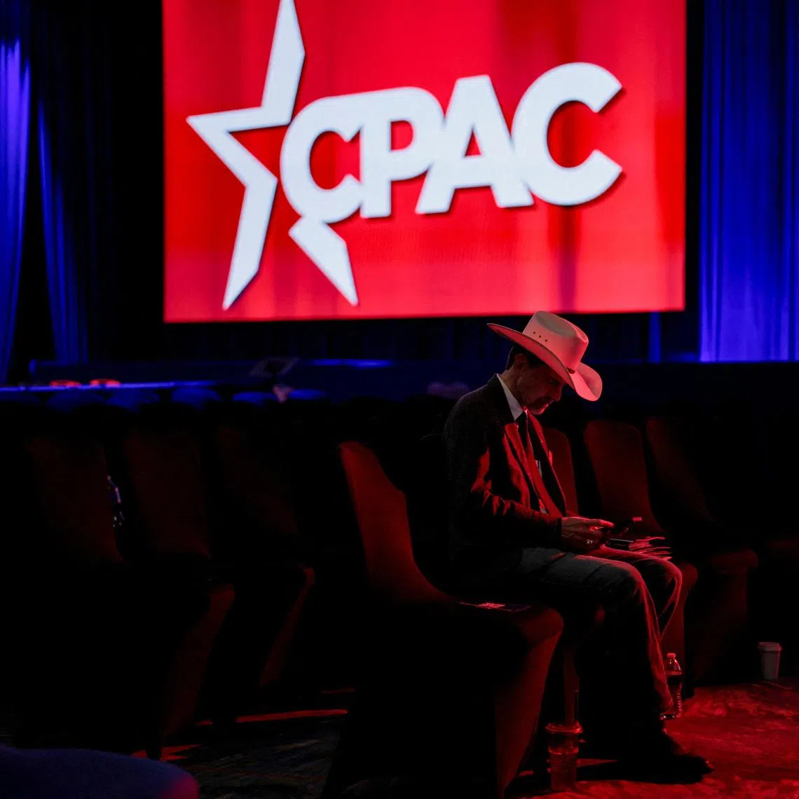 An attendee wearing a hat uses his phone during the 2026 Conservative Political Action Conference (CPAC) in Grapevine, Texas.