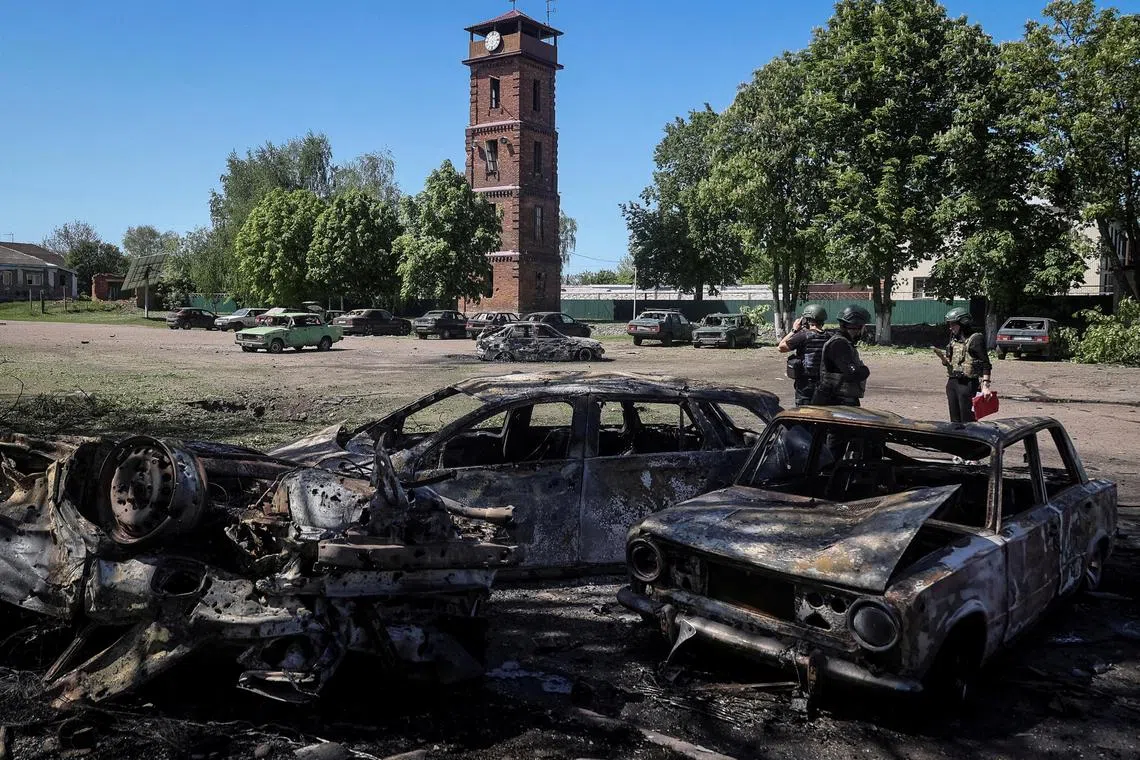Police work at a site of a Russian missile strike, amid Russia's attack on Ukraine, in the village of Zolochiv in Kharkiv region on May 1, 2024.