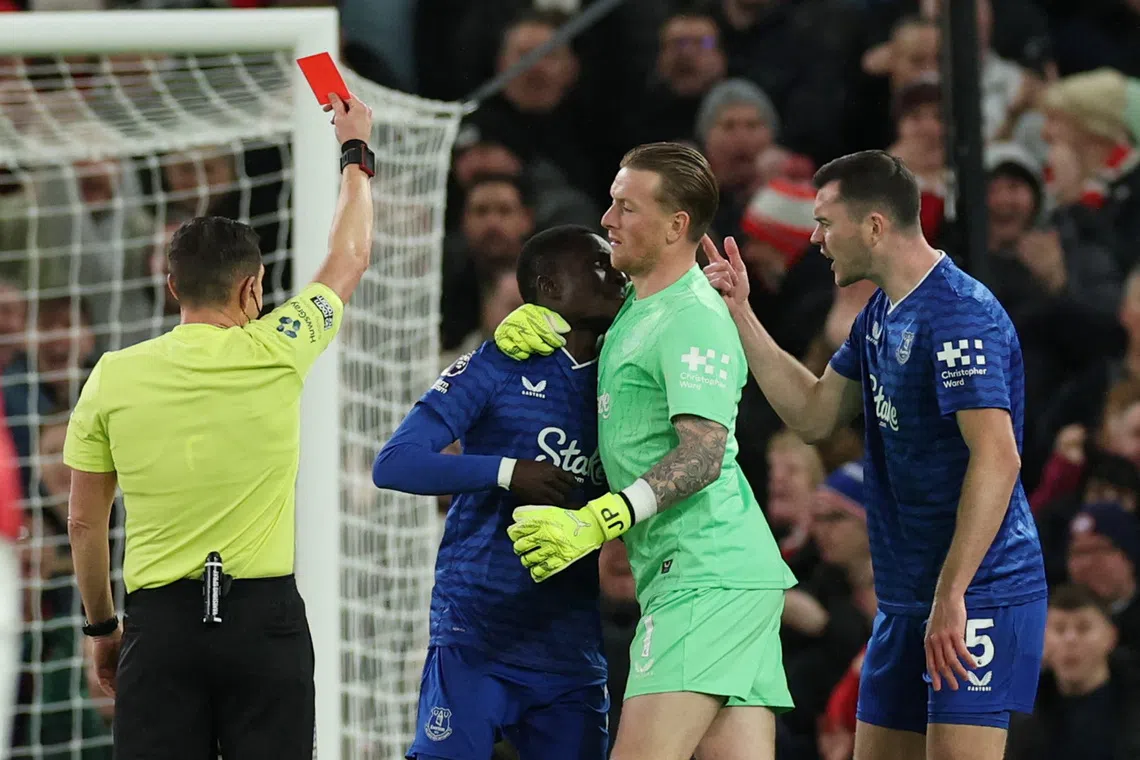 Soccer Football - Premier League - Manchester United v Everton - Old Trafford, Manchester, Britain - November 24, 2025 Everton's Idrissa Gueye is held back by Everton's Jordan Pickford as he clashes with teammate Michael Keane and shown a red card by referee Tony Harrington REUTERS/Phil Noble