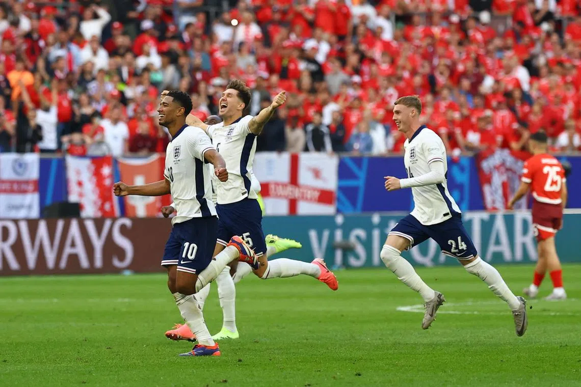 Soccer Football - Euro 2024 - Quarter Final - England v Switzerland - Dusseldorf Arena, Dusseldorf, Germany - July 6, 2024 England's Jude Bellingham, John Stones and Cole Palmer celebrate after winning the penalty shootout REUTERS/Kai Pfaffenbach