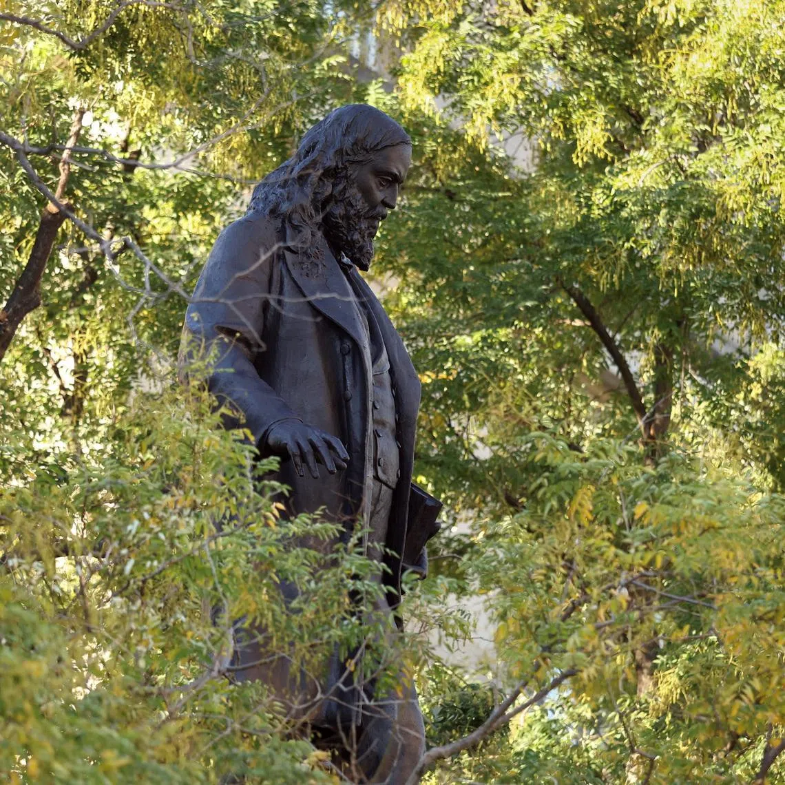 The bronze statue of Confederate Gen. Albert Pike, toppled by demonstrators in 2020, is seen through the trees after being reinstalled this past weekend, a result of U.S. President Donald Trump’s executive order \"Restoring truth and Sanity to American History\" in Washington, D.C., U.S., October 27, 2025. REUTERS/Kevin Lamarque