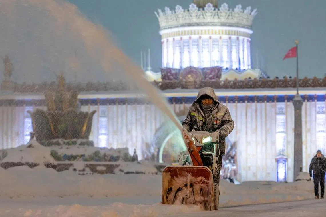 A communal worker cleans snow at the Exhibition of Achievements of National Economy (VDNH) during a heavy snowfall in Moscow, Russia December 3, 2023. REUTERS/Maxim Shemetov