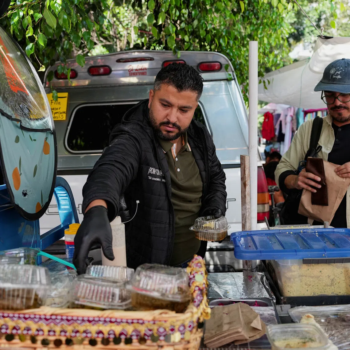Mohammed Abed, 36, a Palestinian systems engineer who arrived in Mexico in 2025 with 17 family members after losing his daughter in an Israeli airstrike in Gaza, sells Palestinian food at an open-air market in the Condesa neighbourhood of Mexico City, Mexico, September 22, 2026. REUTERS/Fred Ramos