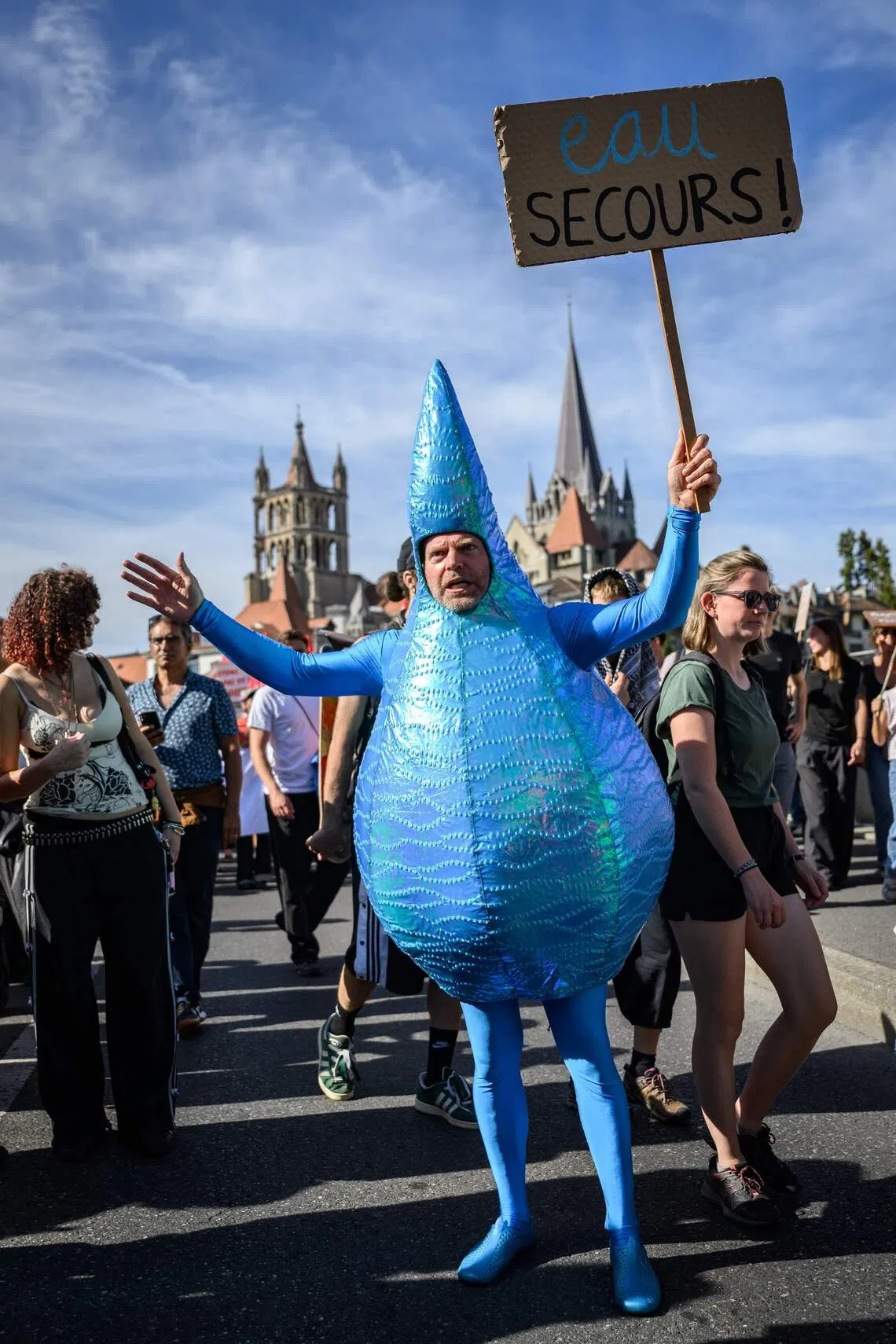 A demonstrator dressed as a drop of water holds a placard reading “Water help!” during a protest in Lausanne, Switzerland, on Sept 19.
