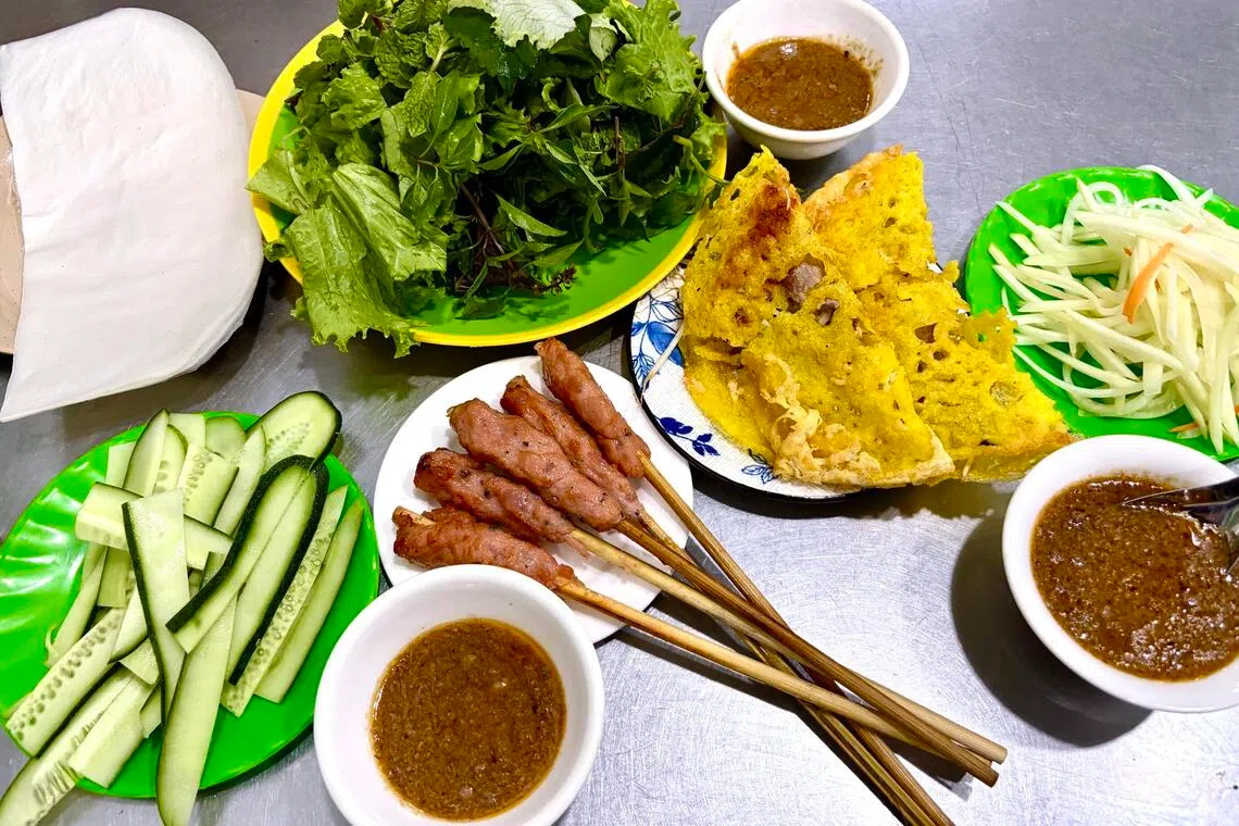 Savour Banh Xeo Ba Duong’s banh xeo with sliced cucumber, pickled papaya and grilled pork skewers.