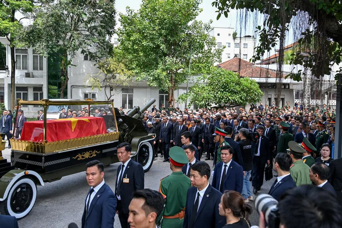 Mourners walk behind the coffin of Vietnam's late Communist Party general secretary Nguyen Phu Trong during his funeral in Hanoi, on July 26.