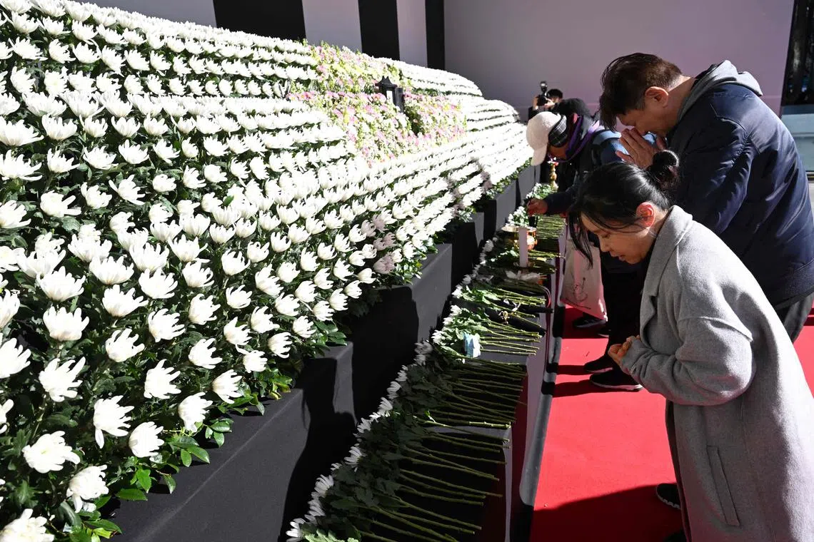 Mourners pay their respects at a memorial altar for the victims of the Jeju Air plane crash, in front of Seoul City Hall in Seoul on Dec 31, 2024.