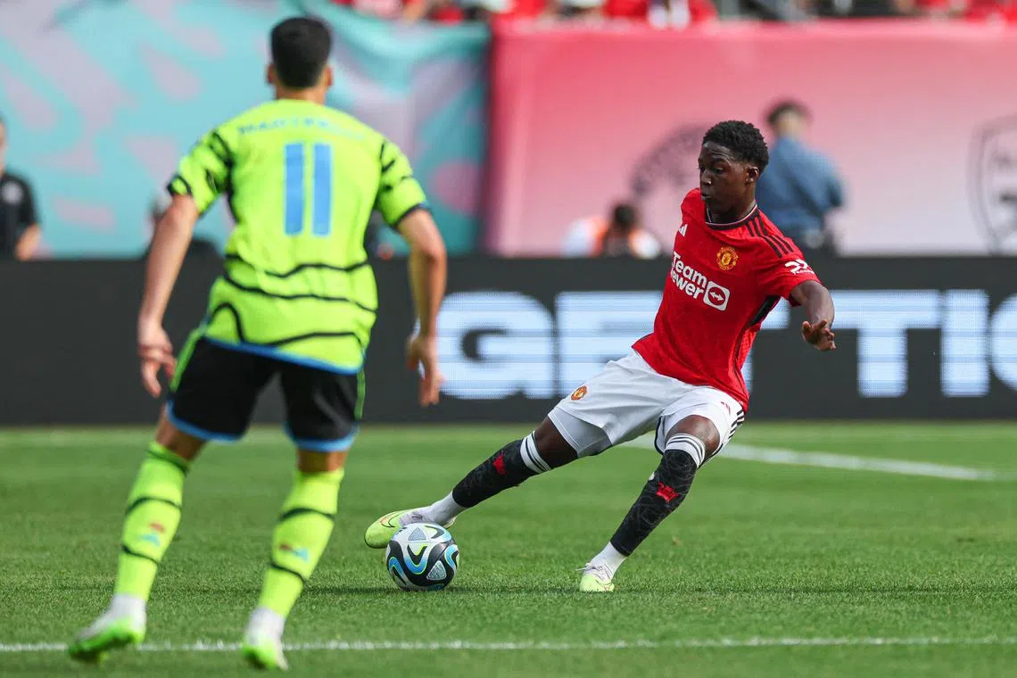 Manchester United midfielder Kobbie Mainoo playing the ball during the first half in front of Arsenal forward Gabriel Martinelli at MetLife Stadium in a friendly on Saturday. The Red Devils won 2-0.