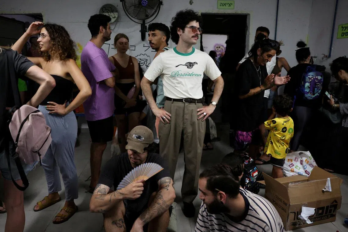 People taking shelter during a siren as missiles are launched from Iran towards Israel, in Tel Aviv, Israel, June 18, 2025. 