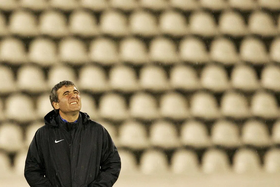 FILE PHOTO: Steaua Bucharest head coach Gheorghe Hagi looks at the sky as it rains during a practice session in Prague September 18, 2007. REUTERS/David W Cerny (CZECH REPUBLIC)/File Photo