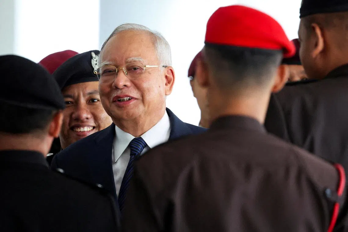 FILE PHOTO: Prison officers escort former Malaysian Prime Minister Najib Razak, as the jailed politician leaves court during a break in proceedings, in Kuala Lumpur, Malaysia, April 4, 2024. REUTERS/Hasnoor Hussain/File Photo