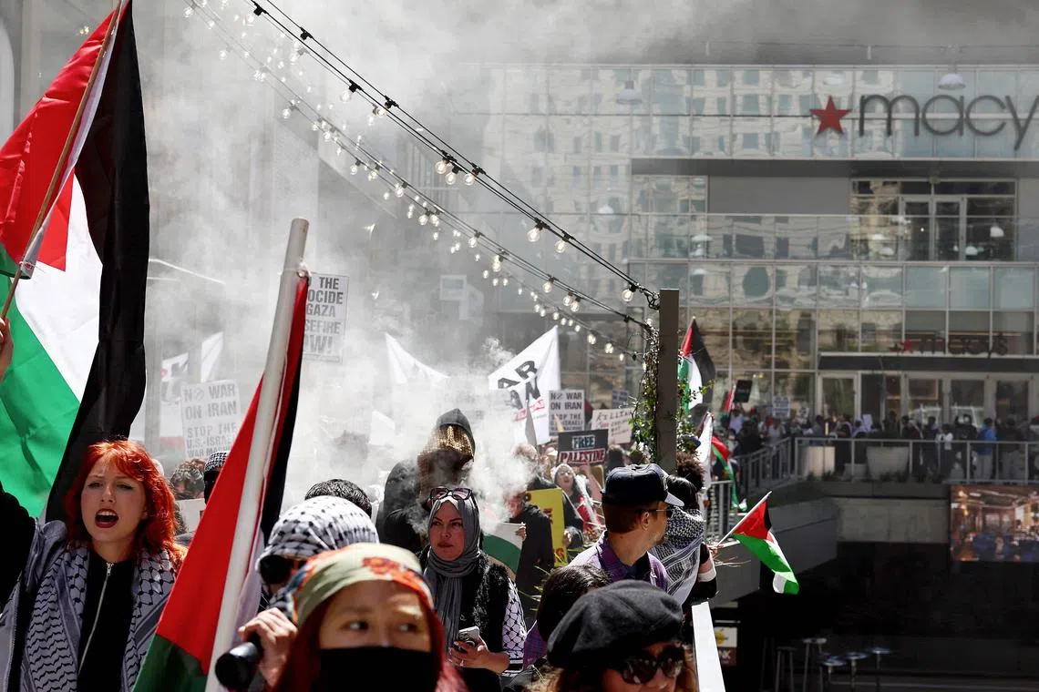 Pro-Palestinian demonstrators protest near a Macy's while occupying an outdoor shopping mall during a 'Strike for Gaza' protest.