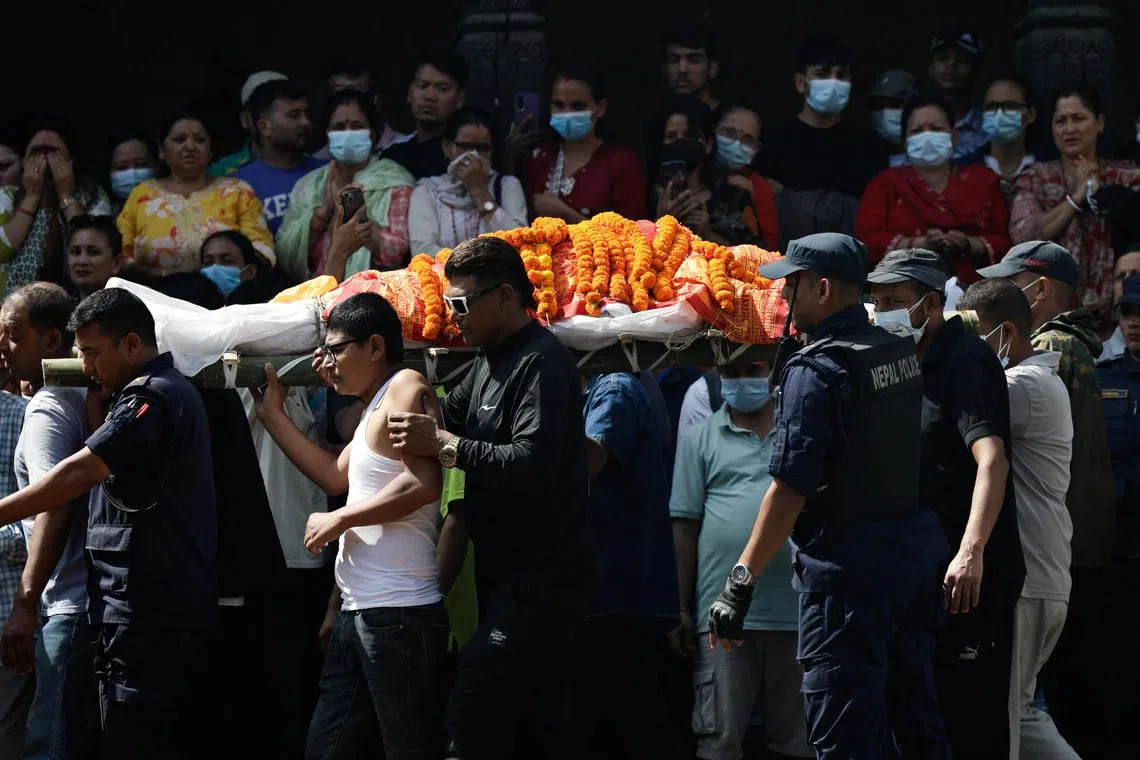People carry the body of a police officer killed in violent anti-corruption protests in Kathmandu, Nepal.