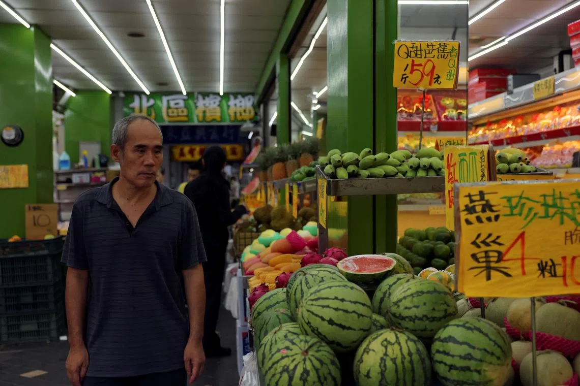 FILE PHOTO: A man walks past a fruits shop in Taipei, Taiwan July 2, 2024. REUTERS/Annabelle Chih/File Photo
