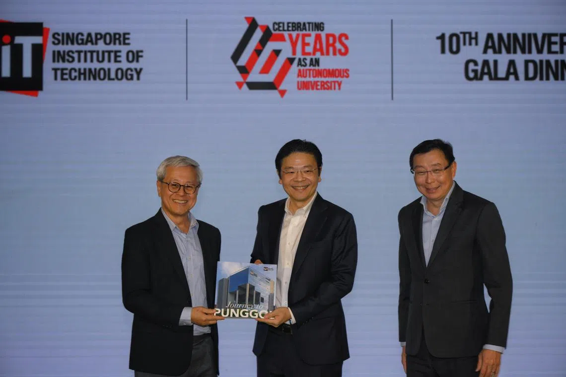 Prof Chua Kee Chiang (left), President, Singapore Institute of Technology (SIT), presents a commemorative book titled 'SIT: Journey to Punggol' to Lawrence Wong, Deputy Prime Minister and Minister for Finance, during SIT’s 10th anniversary gala held at Conrad Singapore Orchard on March 20, 2024. They were accompanied by Bill Chang (right), Chairman, SIT Board of Trustees.