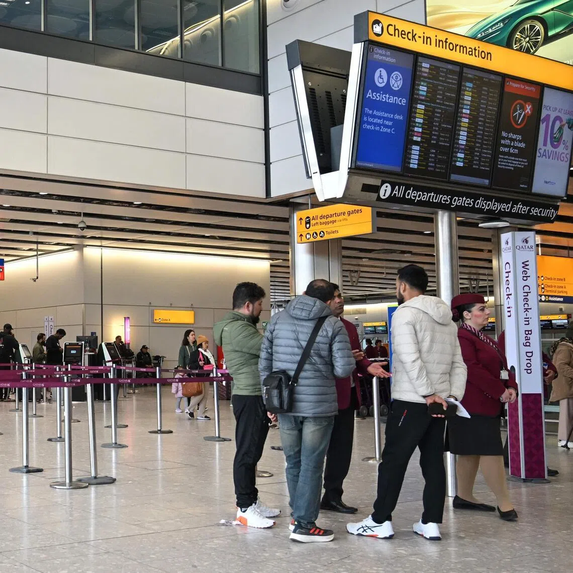 Staff from Qatar Airways helping people with questions at their check-in area at London Heathrow Airport in west London on March 1, 2026, as flights are severely disrupted following the US and Israel's strikes on Iran. The biggest disruption to global air transport since the Covid pandemic continued on March 1, with thousands of flights affected and busy Middle Eastern hubs including Dubai and Doha shuttered as Iran lashed out after US-Israeli strikes. 