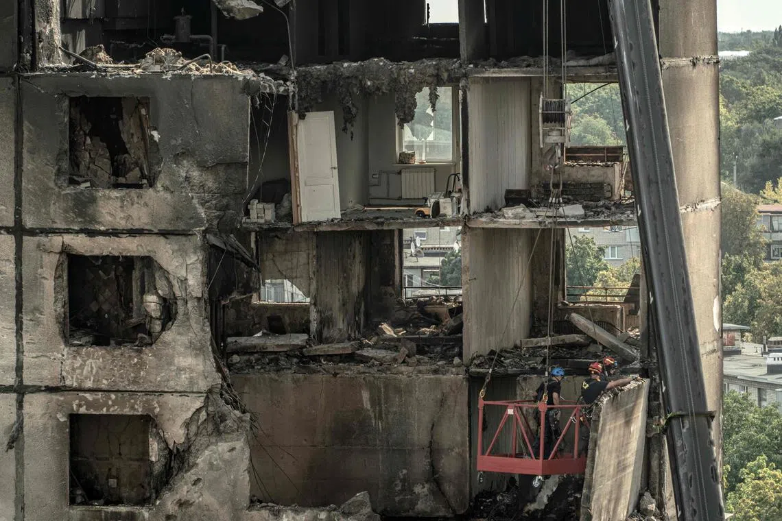 Ukrainian emergency workers inspecting a heavily damaged residential building following a Russian missile strike, in Kharkiv, on Aug 31.