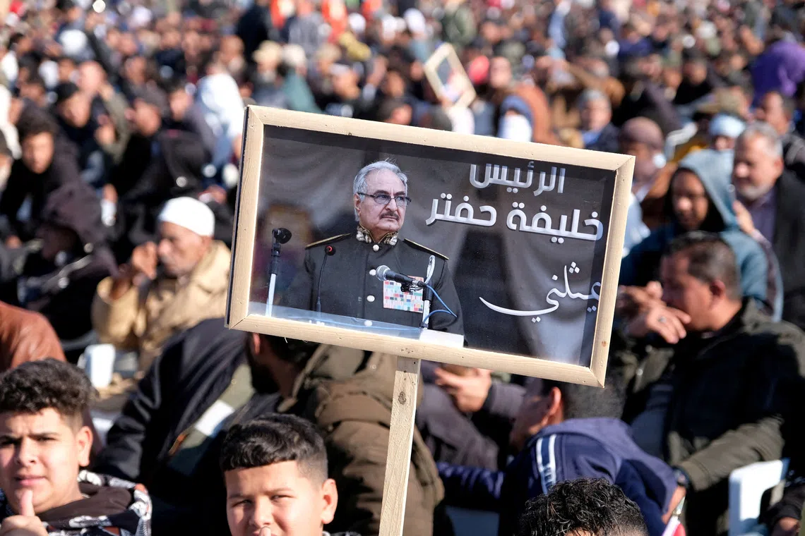 FILE PHOTO: A man holds a picture of commander Khalifa Haftar during Independence Day celebrations in Benghazi, Libya December 24, 2022. REUTERS/Stringer/File Photo