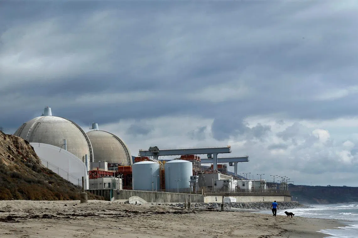 FILE PHOTO: A man walks his dog next to the San Onofre power plant located next to San Onofre State Park in California, November 8, 2012.  REUTERS/Mike Blake/File Photo