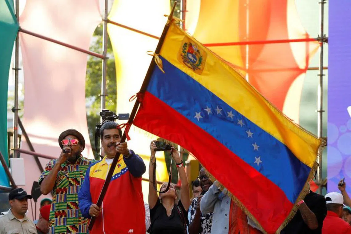 FILE PHOTO: Venezuelan President Nicolas Maduro waves a Venezuelan flag, as he participates in the closing event for the campaign, ahead of the referendum over a potentially oil-rich territory, part of its long-running dispute with its neighbour Guyana, in Caracas, Venezuela, December 1, 2023. REUTERS/Leonardo Fernandez Viloria/File Photo
