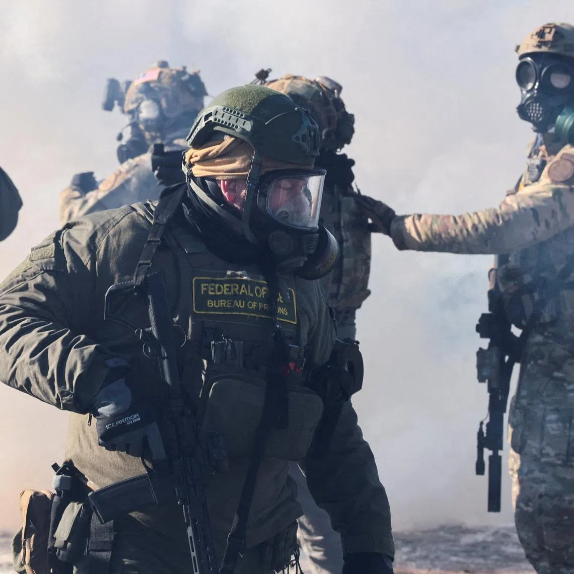 Federal agents stand amid tear gas to disperse people gathered near the scene where federal agents fatally shot a man while trying to detain him, in Minneapolis, Minnesota, U.S., January 24, 2026. REUTERS/Evelyn Hockstein